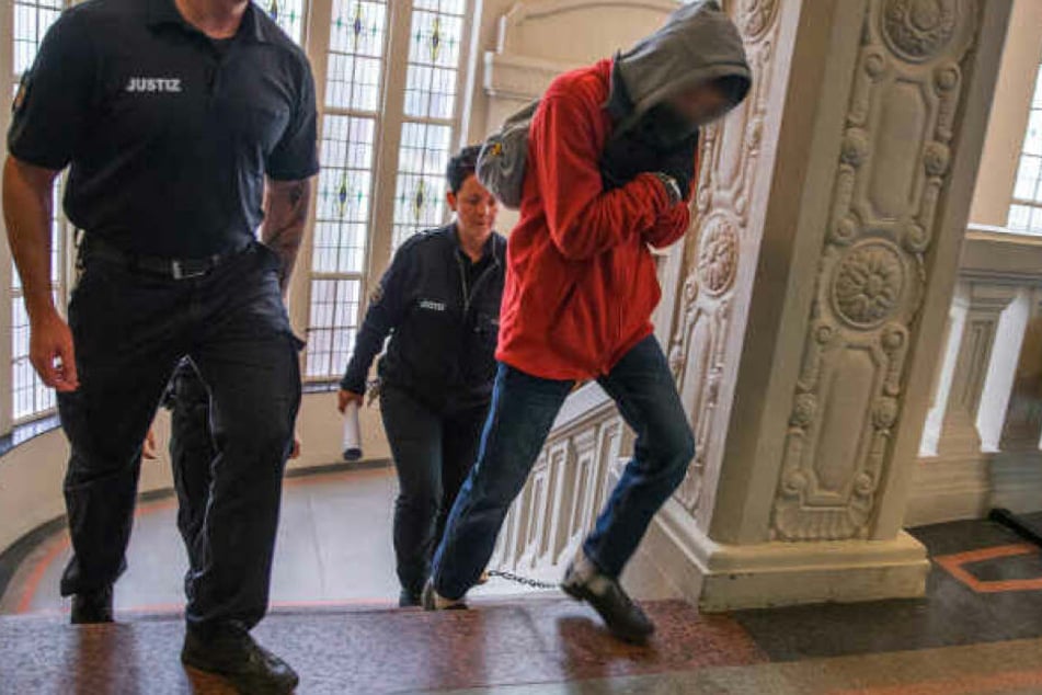 Der Angeklagte wird zum Prozessbeginn um den Mord an einem Rentner in Wittenburg zum Gerichtssaal geführt.