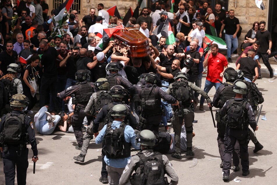 Israeli police forces charging into mourners carrying the coffin of Al Jazeera reporter Shireen Abu Akleh.