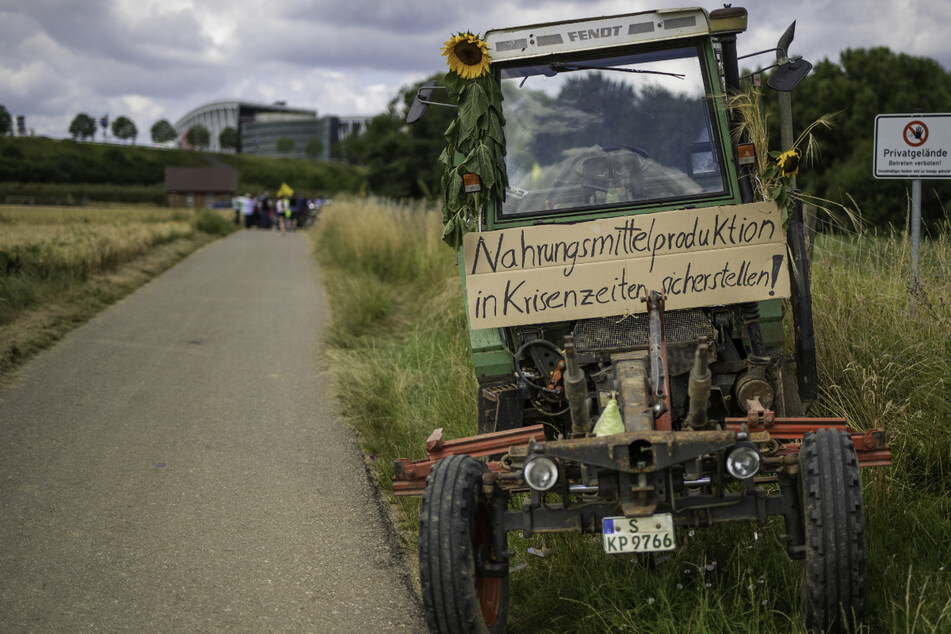 Das Schild auf einem Traktor trägt die Aufschrift: "Nahrungsmittelproduktion in Krisenzeiten sicherstellen!"