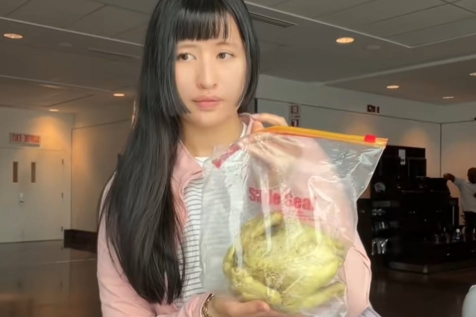 Liliane Lai (27), kurz Lili, hält ihren Reisesnack in die Kamera: ein ganzes Hähnchen.