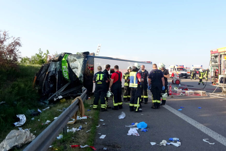 Rettungskräfte stehen vor dem umgekippten Flixbus. Insgesamt mussten 72 Verletzte versorgt werden.