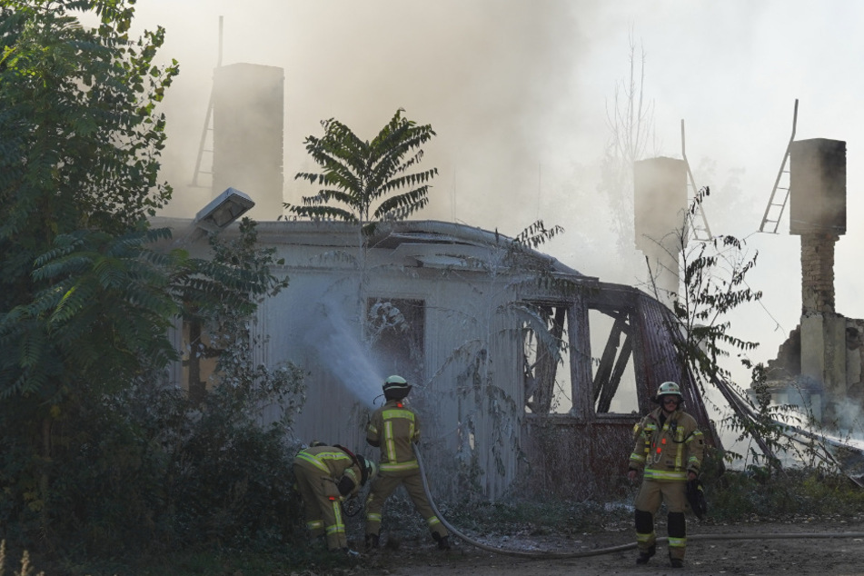 Einsatzkräfte der Feuerwehr löschen eine brennende Holzbaracke in der Dolomitenstraße im Ortsteil Pankow.