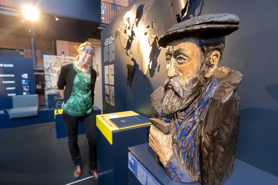 Kuratorin Barbara Würnstl steht im Bereich "Hell und Dunkel" an einer Plastik des sächsischen Minerologen Georgius Agricola.