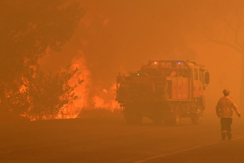 Die Feuerwehr versucht ein Feuer nahe einer Autobahn unter Kontrolle zu kriegen.