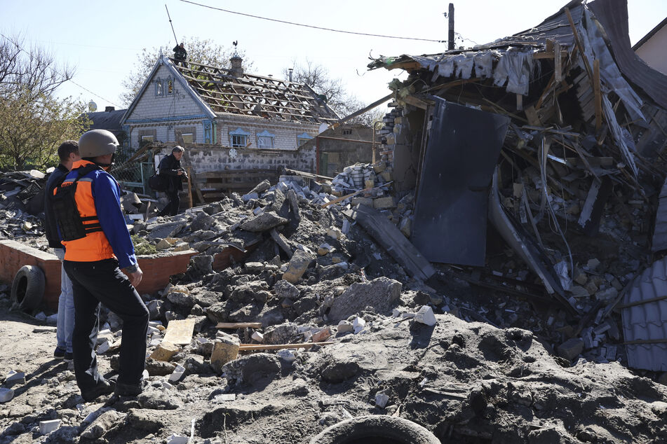 Menschen betrachten Anfang Mai ein Gebäude in Saporischschja, das nach ukrainischen Angaben durch russischen Beschuss zerstört wurde.