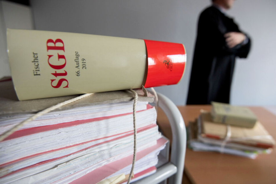 Akten und das Strafgesetzbuch liegen in einem Gerichtszimmer. (Symbolbild)