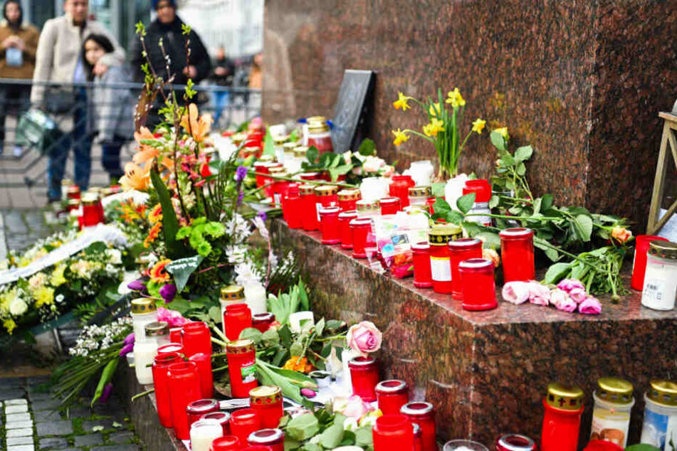 Hanau: Menschen haben am Brüder-Grimm-Denkmal Blumen und Kerzen niedergelegt.