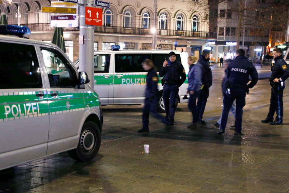 Polizisten stehen am Augsburger Königsplatz am Tatort. Dort war ein 49 Jahre alter Feuerwehrmann bei einer Auseinandersetzung mit Jugendlichen getötet worden.
