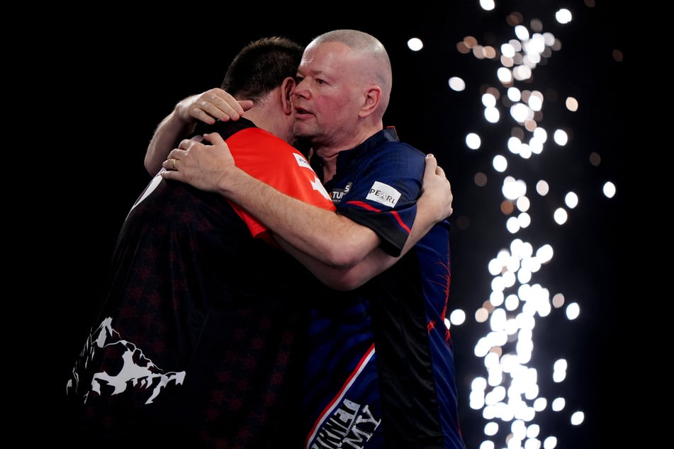 Raymond van Barneveld (r.) objímá svého soupeře Stefana Bellmonta (36) po zápasu.