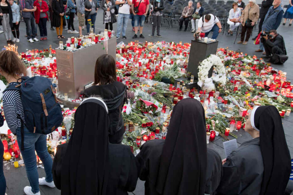 Vor der Kirche legten Menschen Blumen und Kerzen ab.