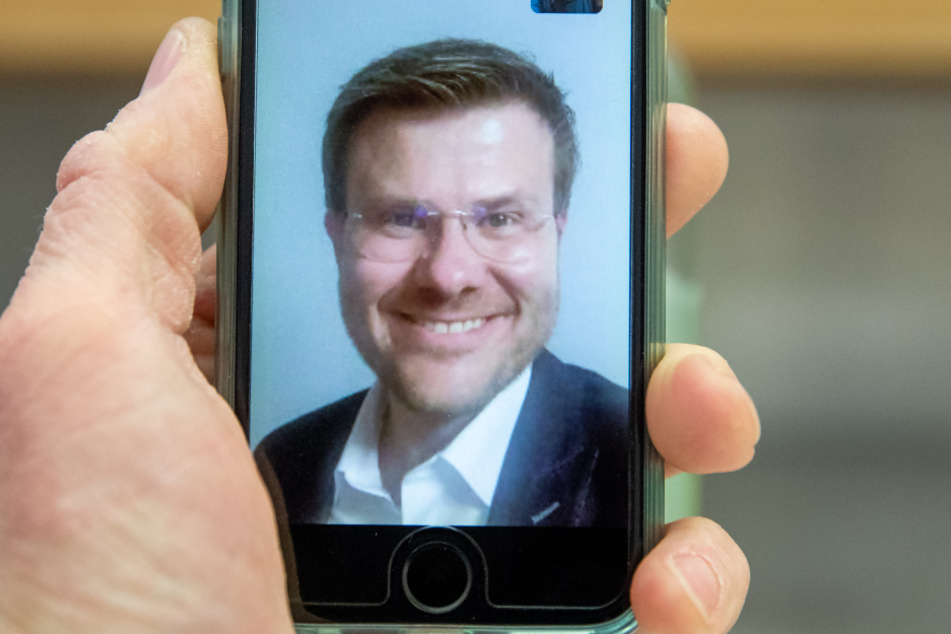 Marcus König, CSU-Spitzenkandidat für das Oberbürgermeisteramt in Nürnberg, lächelt per Video-Anruf nach den Ergebnissen der Auszählungen der Stichwahlen für die Kommunalwahl in die Kamera.
