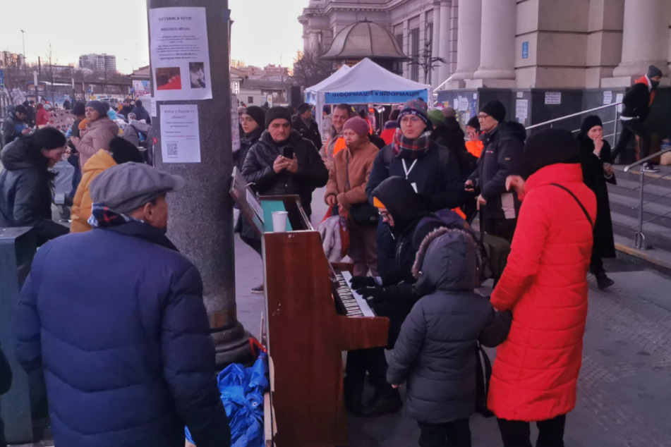 Der Haupbahnhof in Lwiw. Ab hier fahren kostenlose Züge und Busse nach Polen. Zwei Männer sorgen mit Klavier und Gesang für bessere Stimmung.