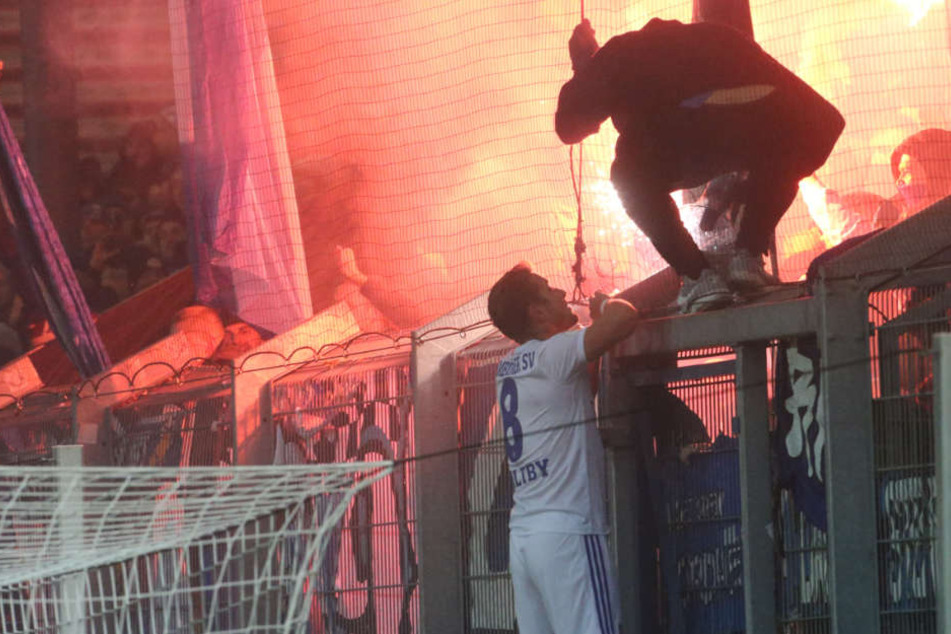 Spielunterbrechung wegen Pyrotechnik: HSV-Spieler Pierre-Lewis Holtby redet den Fans ins Gewissen.