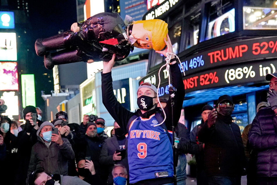 Ein Demonstrant hält eine Donald-Trump-Puppe nach oben.