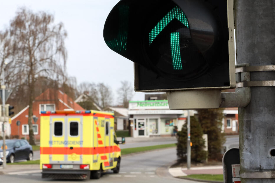 Ein Rettungswagen fährt an einer grünen Ampel vorbei.