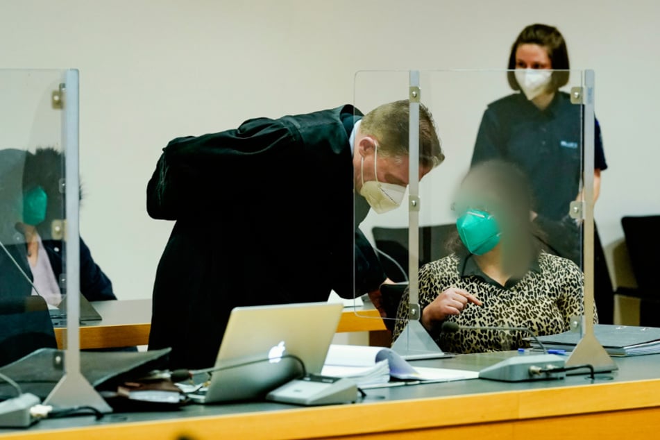 Eine der beiden Angeklagten spricht mit ihrem Anwalt Markus Schwab im Verhandlungssaal des Landgerichts. Links im Hintergrund sitzt die zweite Angeklagte.