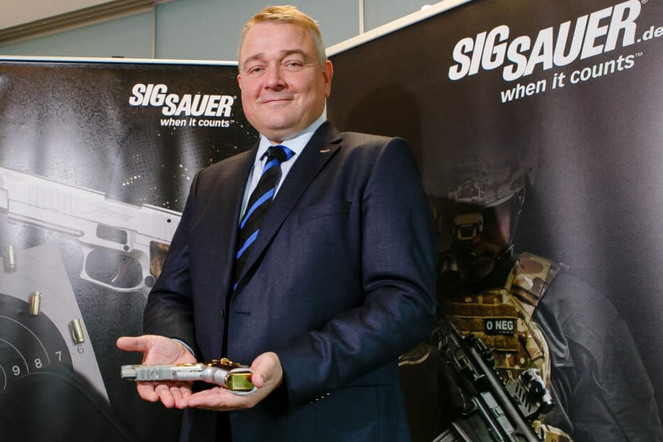 Der deutsche Sig Sauer-Geschäftsführer Tim Castagne hält eine P226 X-Five Violine-Sportpistole in den Händen.