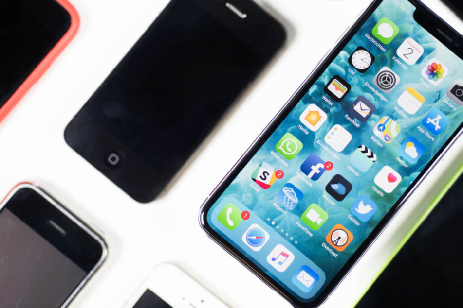 Ein iPhone X liegt neben iPhones anderer Generationen auf einem Tisch (Archivbild).
