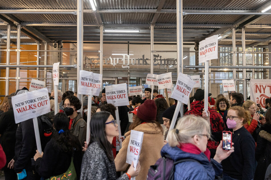 Guild members hold placards supporting the walkout outside the New York Times' Manhattan headquarters.