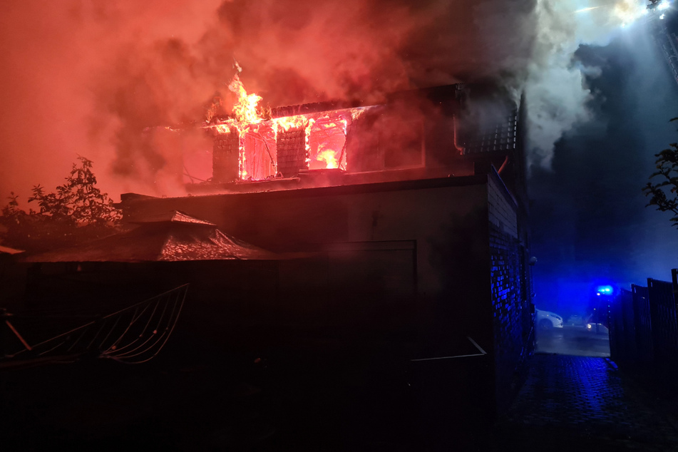 Flammen und Rauch schossen aus dem Dachgeschoss des Gebäudes.