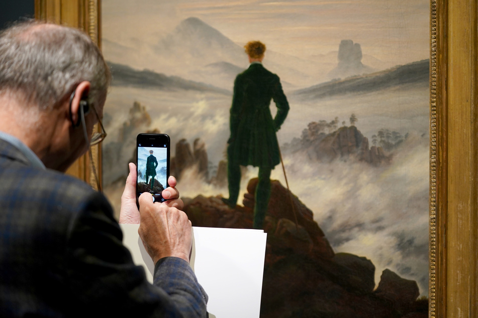 Ein Besucher fotografiert das Bild "Wanderer über dem Nebelmeer" von Caspar David Friedrich in der Hamburger Kunsthalle.