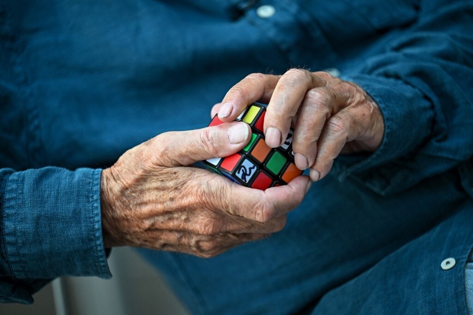 Hungarian inventor Erno Rubik holds a Rubik's Cube 3D puzzle in his hands.