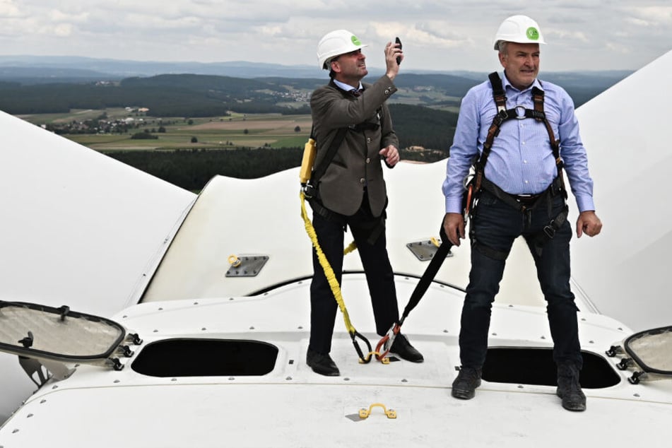 Der bayerische Wirtschaftsminister Hubert Aiwanger (l.) und der Geschäftsführer der Bürgerwindenergie Gebenbach GmbH & Co. KG, Erich Wust, stehen auf dem Gondeldach des Windrads des Bürgerenergieparks Gebenbach.