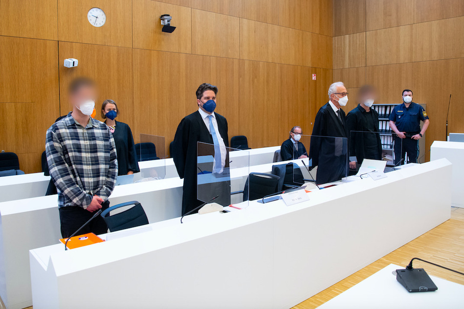 Die zwei wegen Mordes angeklagten Männer (l. und 2.v.r.) stehen mit ihren Anwälten Sarah Stolle und Alexander Betz (3.v.l.), Patrick Ottmann (4.v.r.) und Gerhard Bink (3.v.r.) im Sitzungssaal.