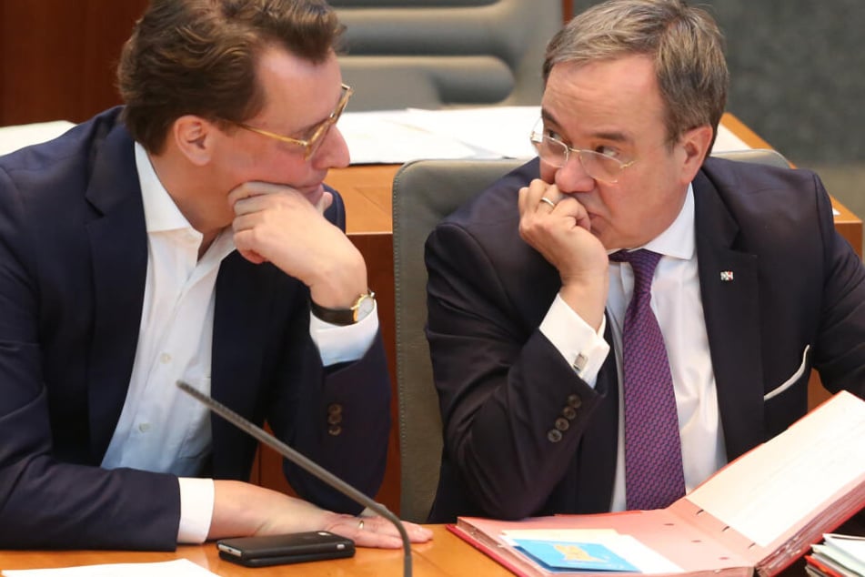 Der nordrhein-westfälische Verkehrsminister Hendrik Wüst (CDU, l) spricht auf der Ministerbank mit Ministerpräsident Armin Laschet (CDU).