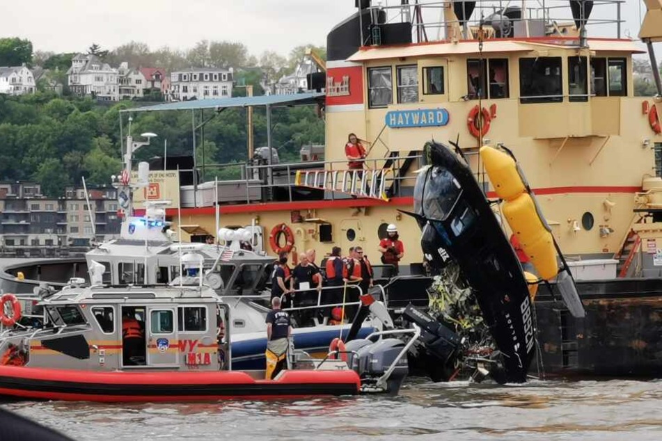 Rettungskräfte ziehen den Helikopter aus dem Wasser.