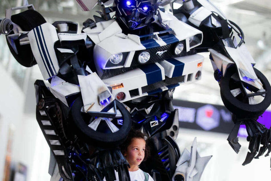 Der kleine Noah steht auf der Comic und Filme-Messe "Comic Con Experience" (CCXP) vor einer Figur aus den "Transformers"-Filmen Transformers.