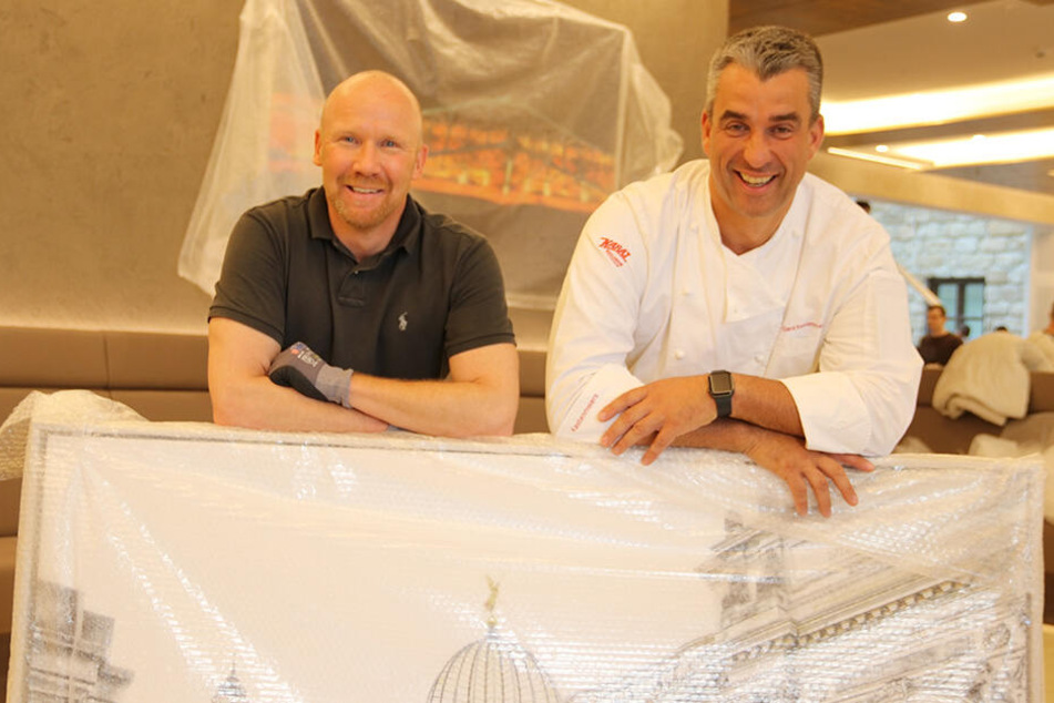 Carsten Linke (l.) und Gerd Kastenmeier hängen die ersten Bilder für die Ausstellung auf.