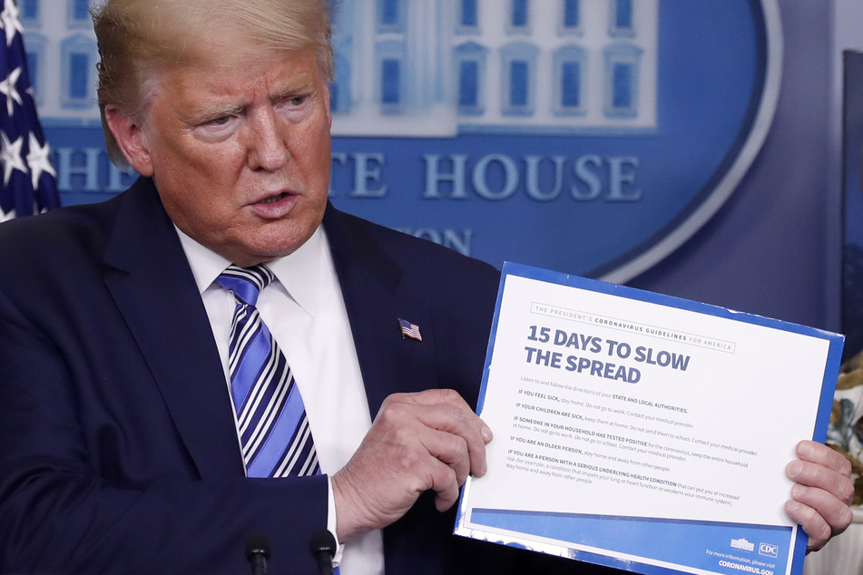 Donald Trump, Präsident der USA, hält während einer Pressekonferenz zur Corona-Pandemie im Weißen Hauses ein Schild mit der Aufschrift "15 Tage, um die Ausbreitung zu verlangsamen".