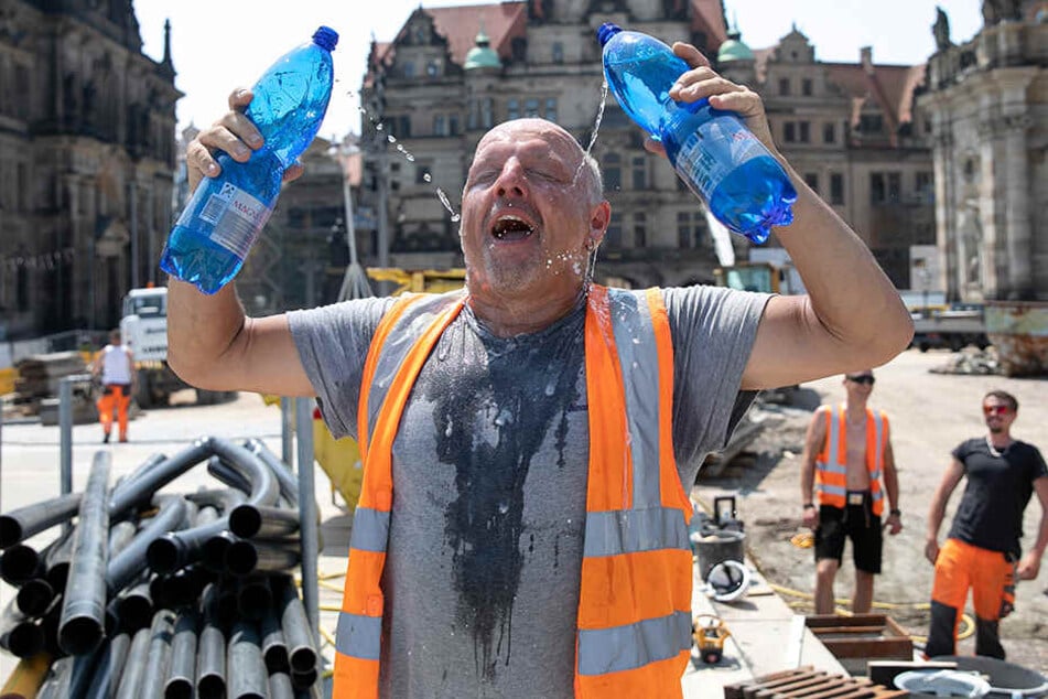 Diese Hitze! Hentschke Bau-Vorarbeiter Uwe Juchler (52) gönnt sich am Schloßplatz eine Wasserdusche.