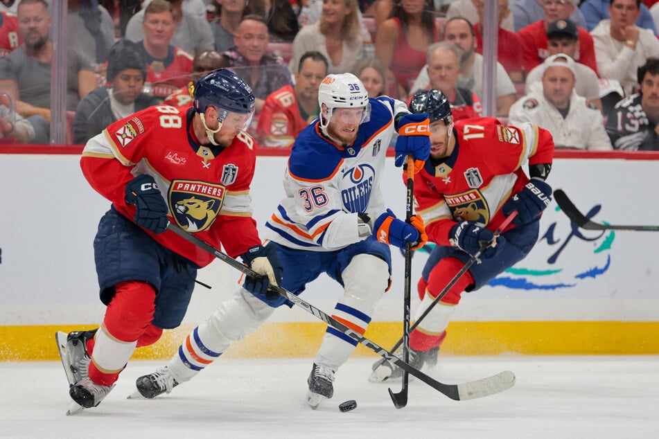 Edmonton Oilers defenseman John Klingberg battles Florida Panthers defenseman Nate Schmidt and center Evan Rodrigues for the puck during the first period in game six of the 2025 Stanley Cup Final.