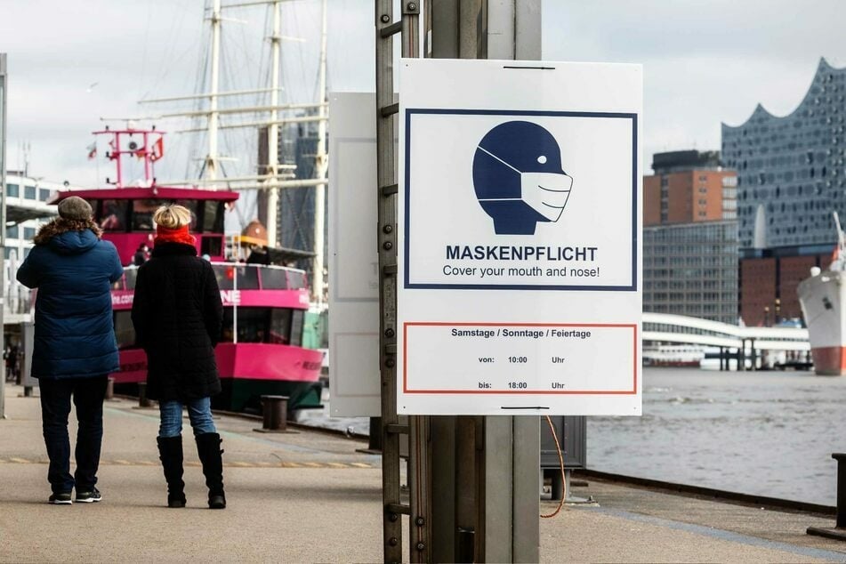Ein Hinweisschild mit der Aufschrift "Maskenpflicht" hängt an den Landungsbrücken in Hamburg.