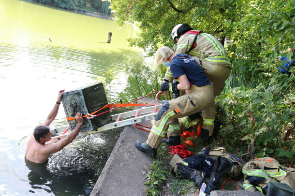 Einsatzkräfte der Feuerwehr ziehen einen Tresor aus dem Obersee in Berlin.