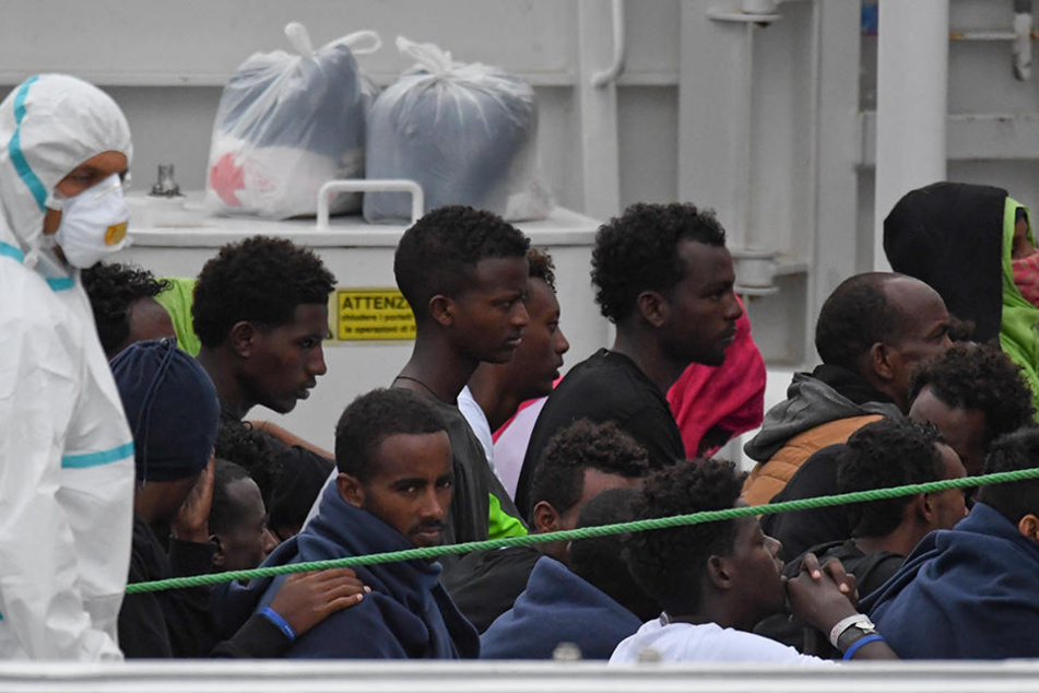 Migranten stehen an Deck des italienischen Küstenwachschiffs "Diciotti", das nach mehreren Tagen im Mittelmeer in den von Hafen Catania eingelaufen ist.