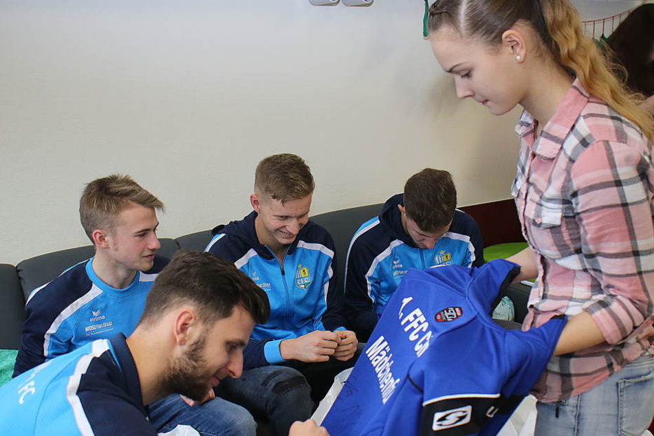 CFC-Spieler beim Signieren der Trikots.