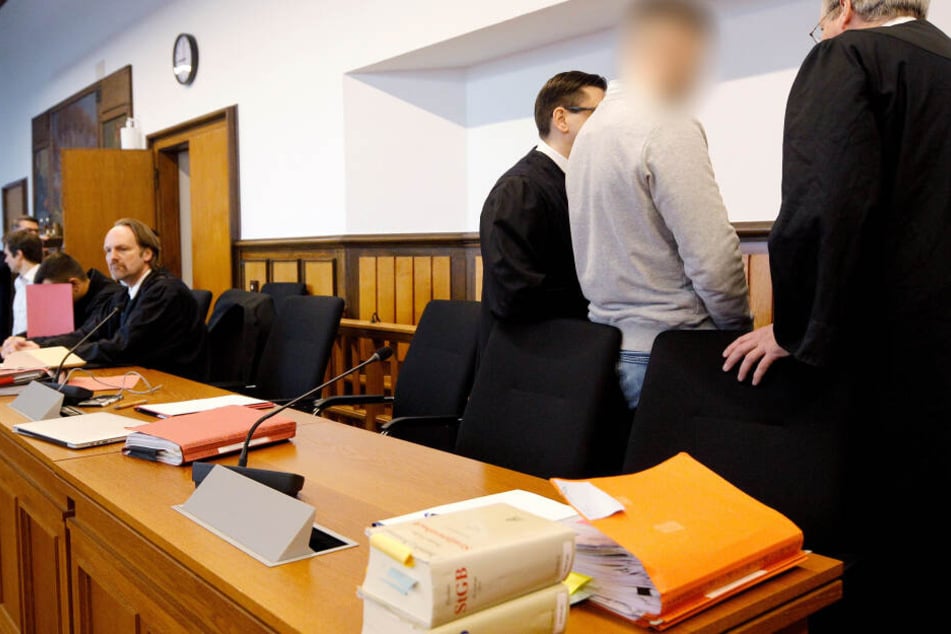 Der Hauptangeklagte (2.v.r) und der Mitangeklagte (2.v.l, mit rotem Ordner)