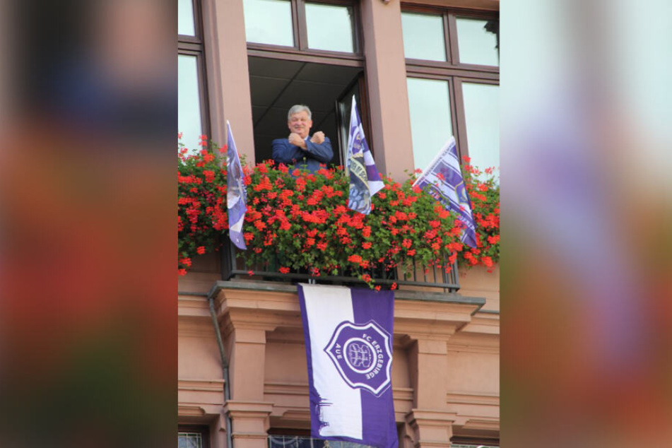 Aue zeigt Flagge: Oberbürgermeister Heinrich Kohl ließ den Rathausbalkon mit lila-weißen FCE-Vereinsfahnen schmücken und grüßt mit den traditionellen gekreuzten Hämmern.