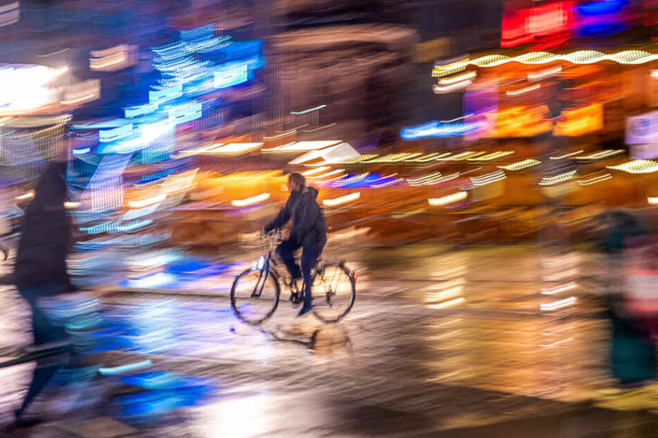 Ein Radler fährt bei Regenwetter durch die Dresdner Altstadt.