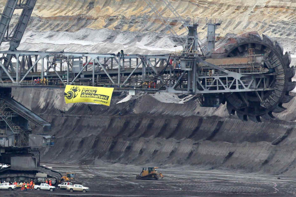 An einem Braunkohle-Bagger hängt ein Plakat mit der Aufschrift "Kohle abschalten ! Greenpeace".