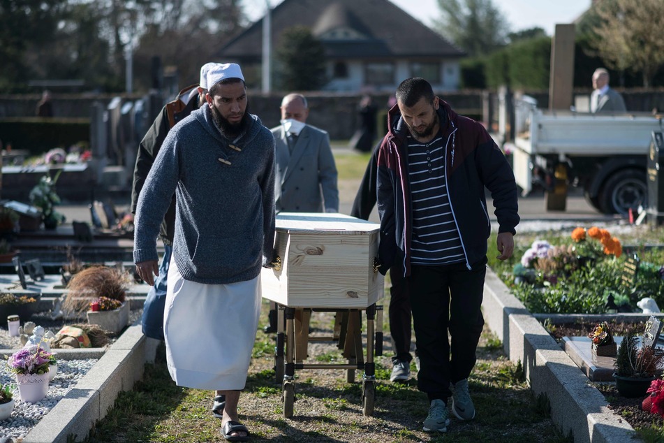 In der französischen Stadt Wittenheim tragen Angehörige und Religiöse während einer islamischen Beerdigung den Sarg eines Mannes, der am Coronavirus verstorben ist.
