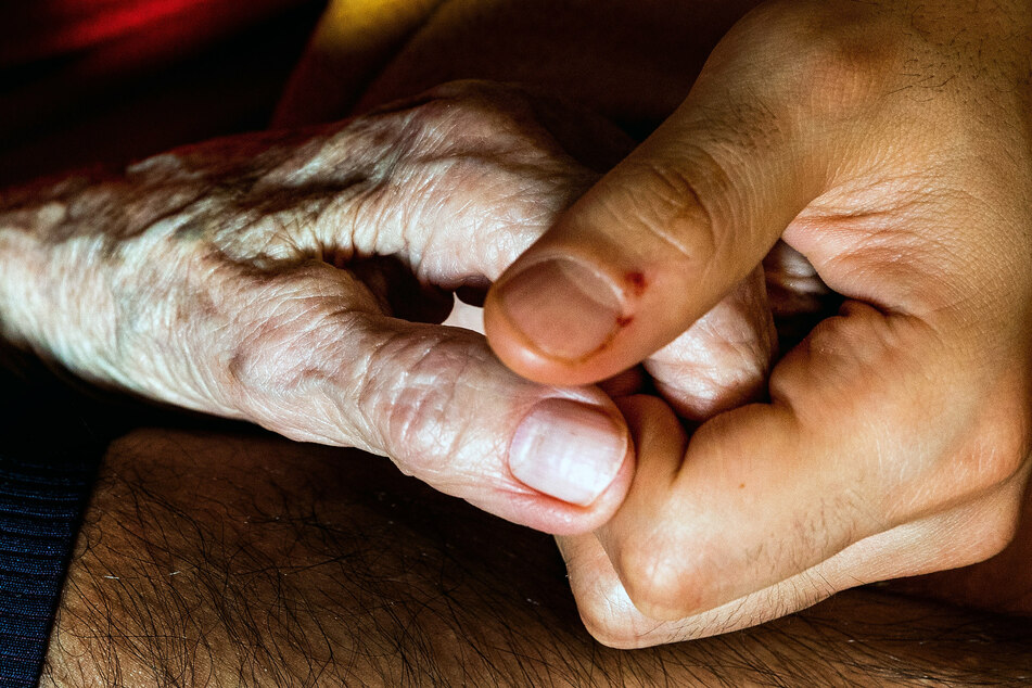 Agnes Jeschke (101, l.) legt ihre Hand in die Hand von ihrem Mitbewohner Amir Farahani. (28). Er macht zurzeit eine Ausbildung zum Pflegefachmann, arbeitet nebenbei als Pflegehelfer im Altersheim.