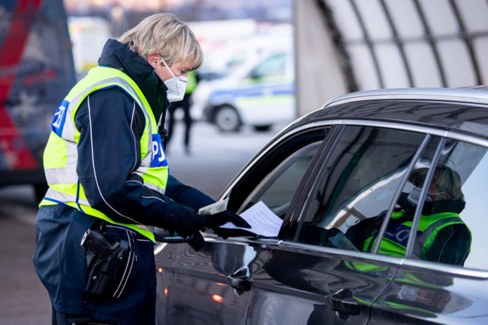 Eine Bundespolizistin kontrolliert die Dokumente eines aus Österreich kommenden Reisenden an einer Kontrollstelle an der Autobahn A93 bei Kiefersfelden in Richtung Deutschland.