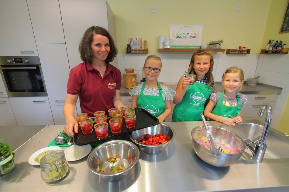 Ernährungsexpertin Elžbjeta Hoyer (34) bereitet mit den Kindern Melina (9, v.l.n.r.), Saphira (9) und Aileen (7) einen gesunden Beeren-Spritz zu.