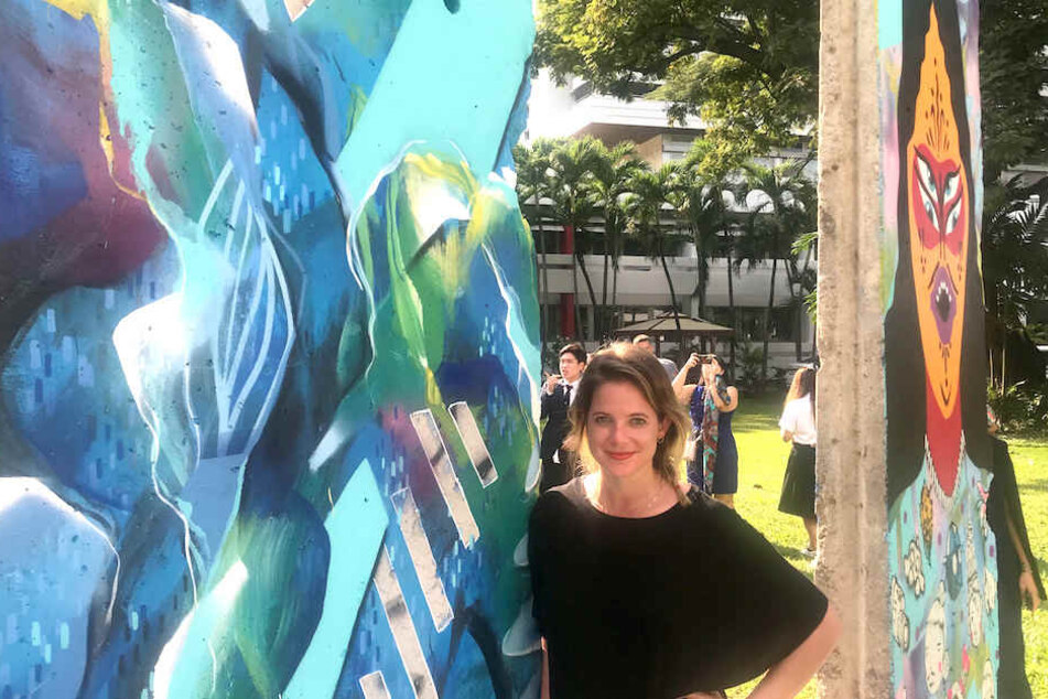 Die Berliner Künstlerin Julia Benz (33) mit den von ihr mitbemalten Teilen der Mauer.