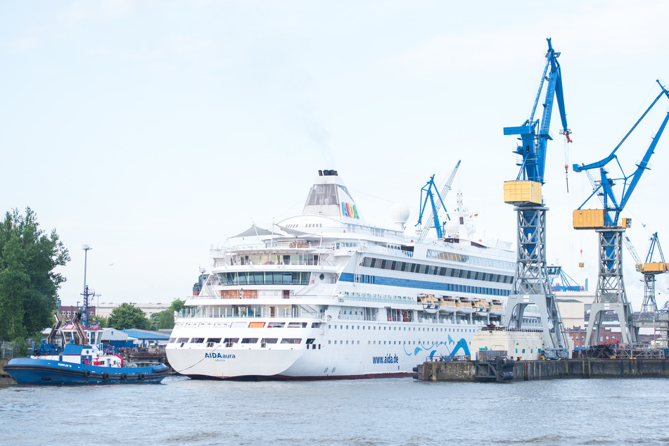 Das Kreuzfahrtschiff "AIDAaura" dockt bei der Werft Blohm+Voss ein.
