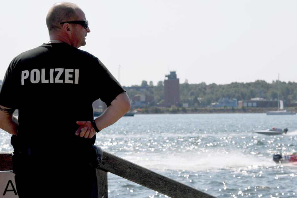 Ein Polizist steht bei der Kieler Woche an der Förde.